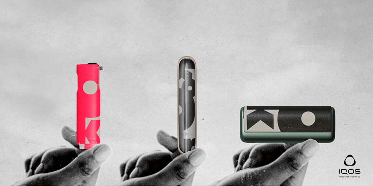 Vaper che tiene in mano tre dispositivi IQOS ILUMA con le varie versioni degli accessori Kolor in edizione limitata