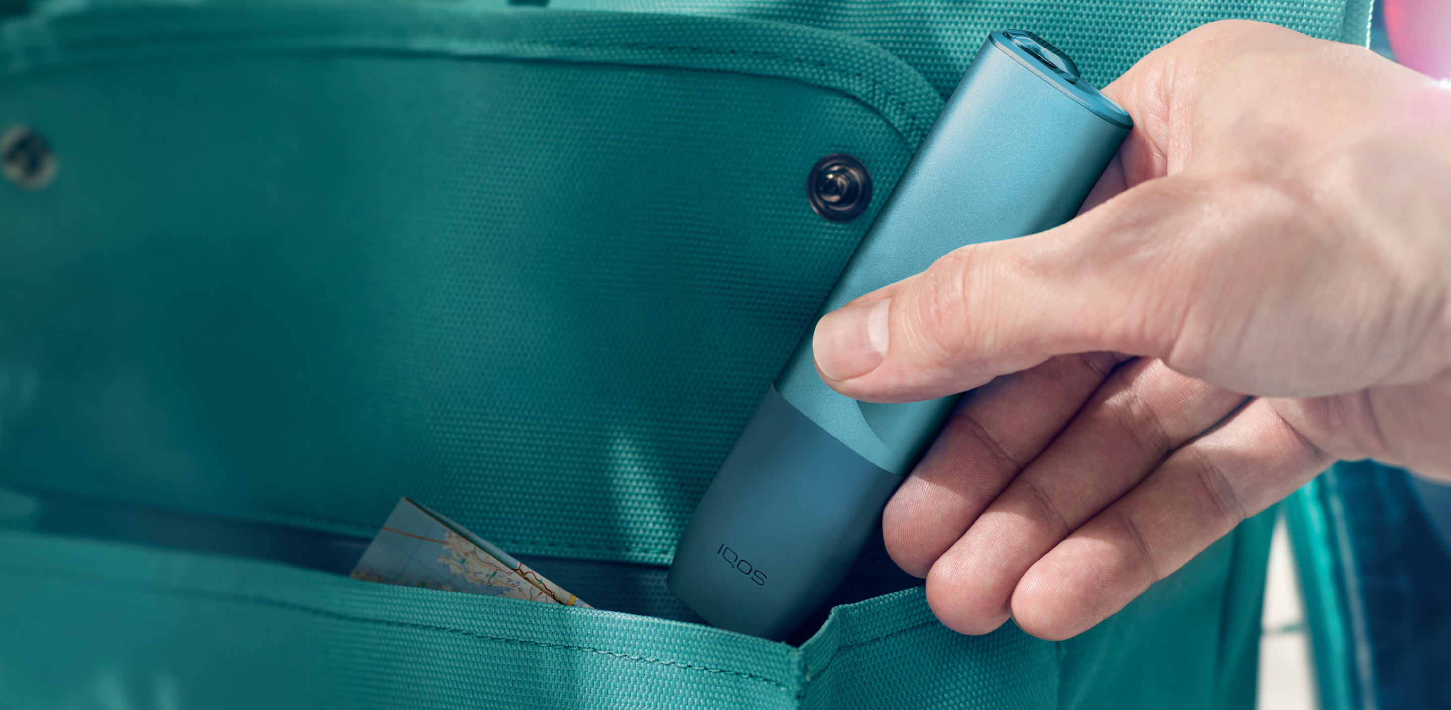 An IQOS ILUMA device in a person's hand.