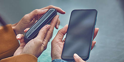 Man checking his phone with the IQOS device on the table