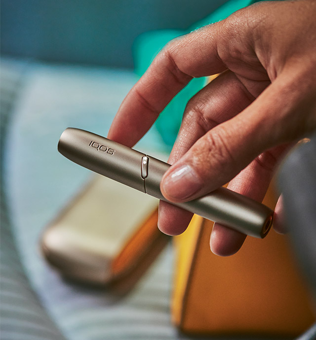 La mano di una persona con un dispositivo IQOS