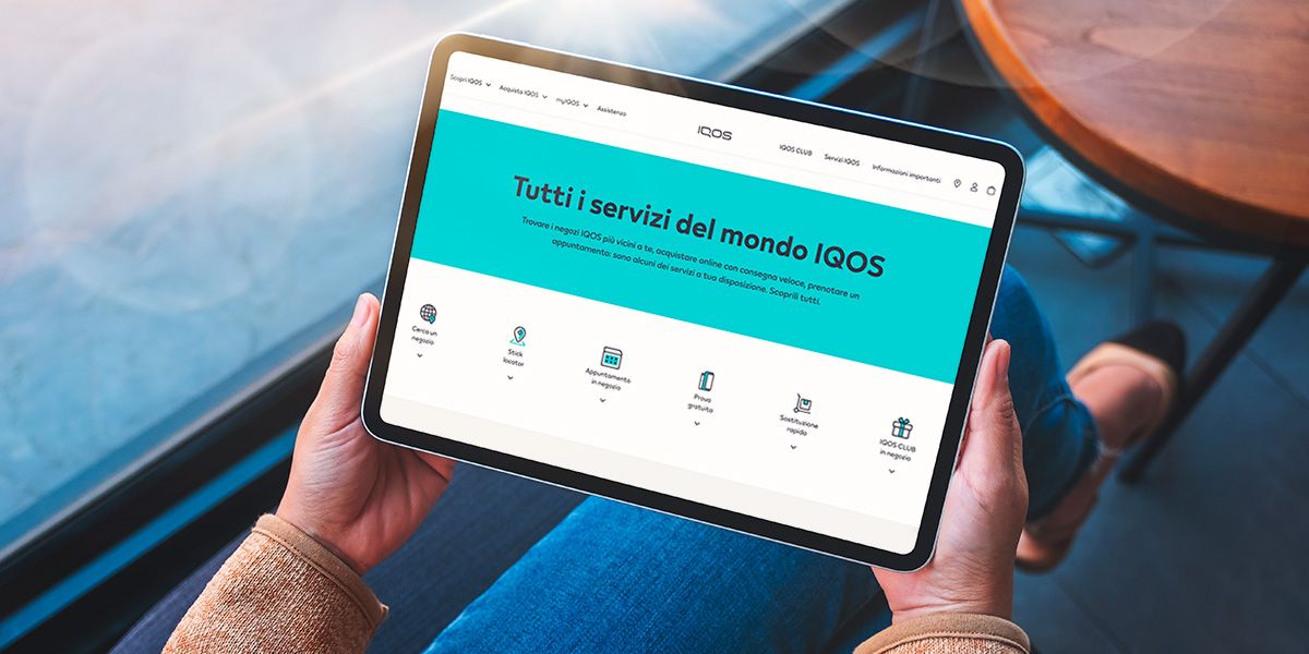 Utente con tablet che naviga sul sito IQOS Italia per informazioni sui servizi di IQOS