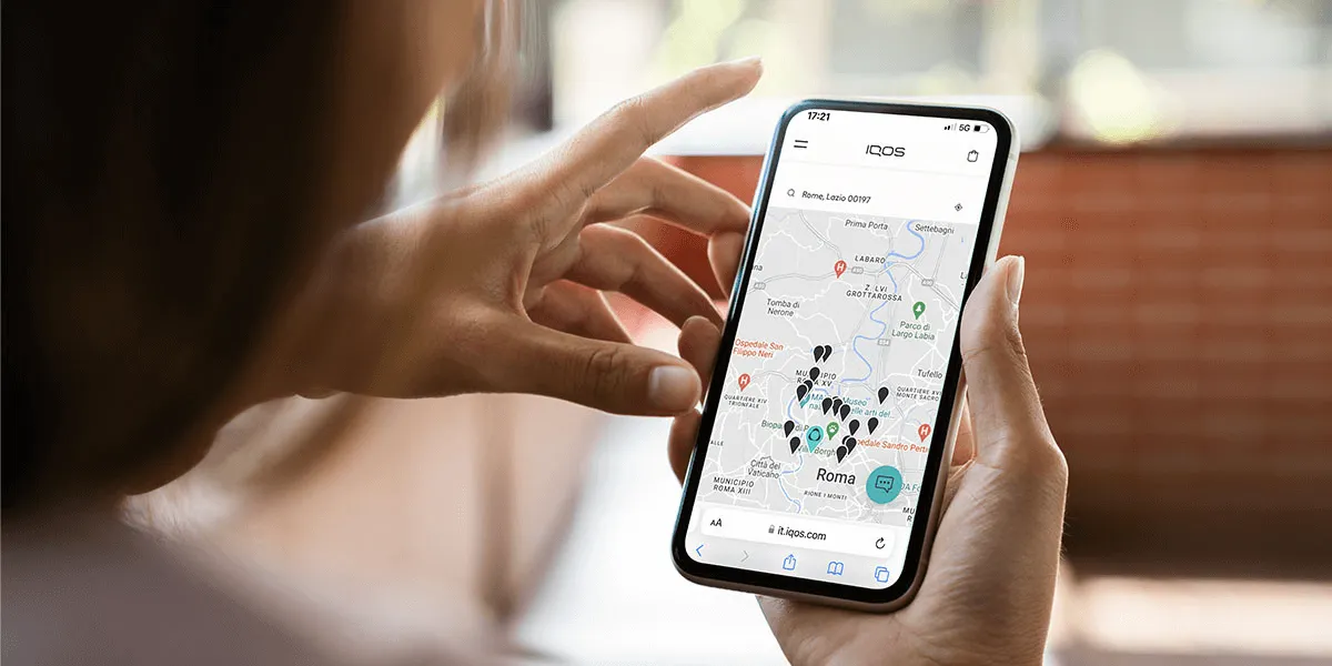 una donna cerca sulla mappa le tabaccherie nelle vicinanze dove trovare gli SMARTCORE STICKS™ per IQOS ILUMA in Italia.