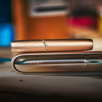 Holder e charger IQOS 3 DUO brilliant gold su una fisarmonica