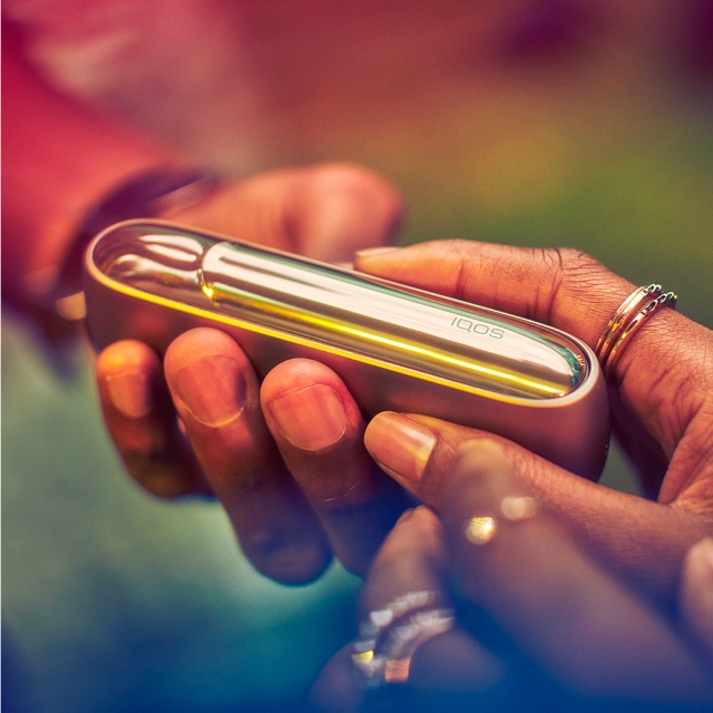 A person holding an IQOS device.