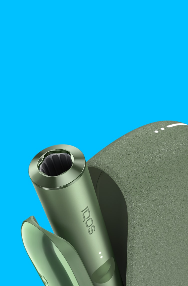 A Moss Green IQOS ILUMA device inside a charger with its door open.
