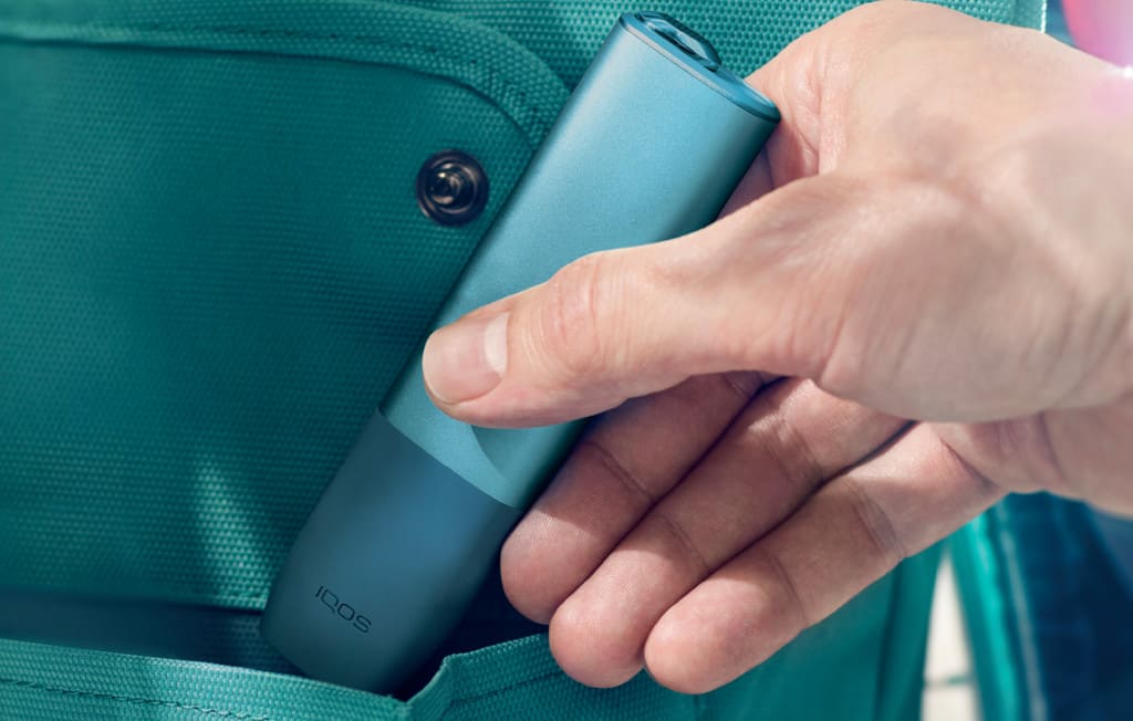 Un dispositivo IQOS ILUMA PRIME su una chitarra.
