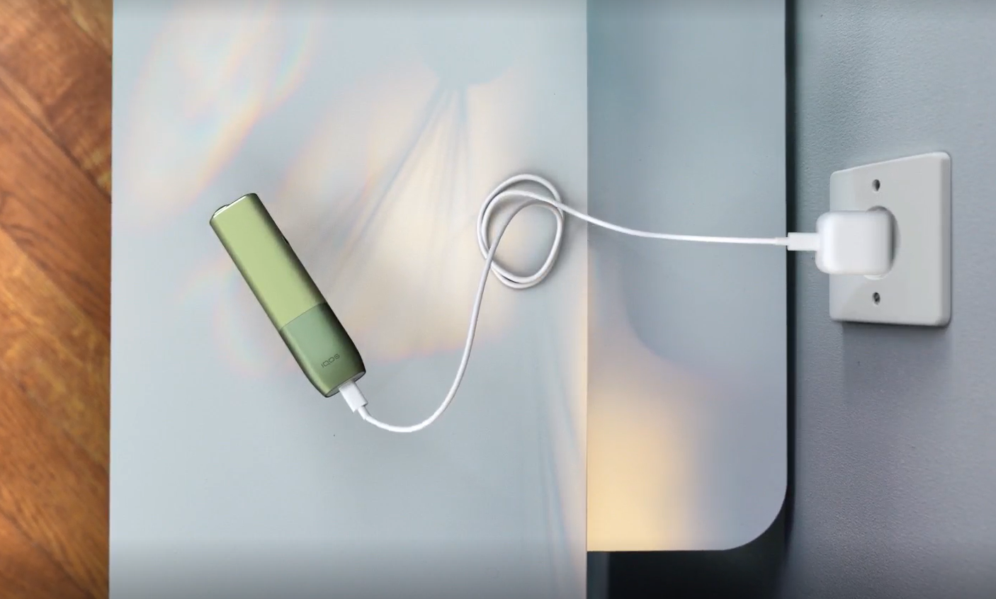 A charging cable being inserted into an IQOS ILUMA Holder.