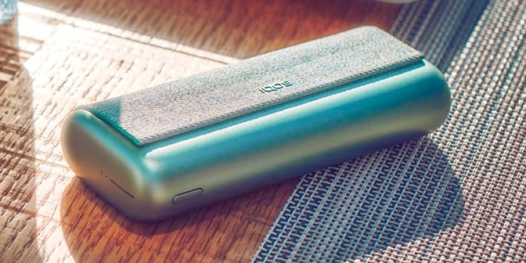 A Jade Green IQOS ILUMA PRIME Pocket Charger on a table.