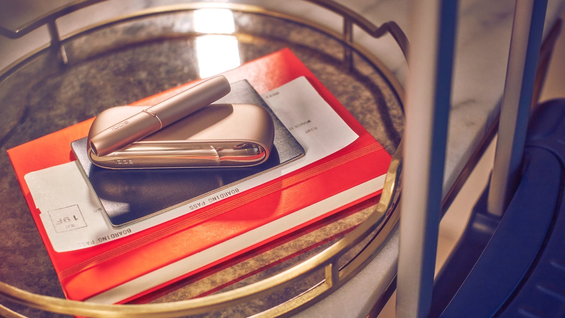 Un IQOS 3 DUO Gold su un libro arancione