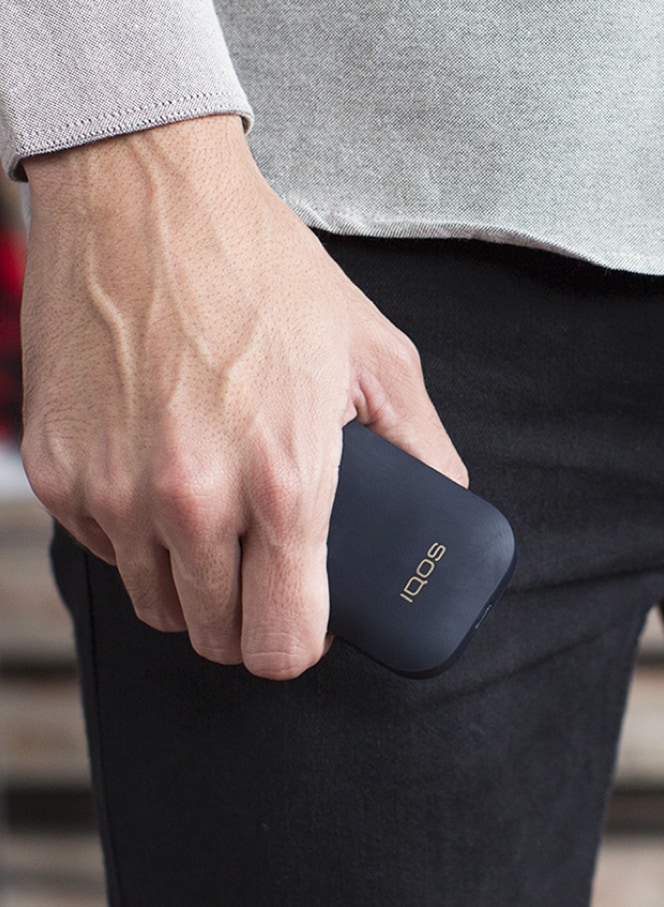 A mobile and a gold IQOS kit on a table