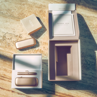 IQOS Duo gold fuo dalla sua scatola su un tavolo di legno