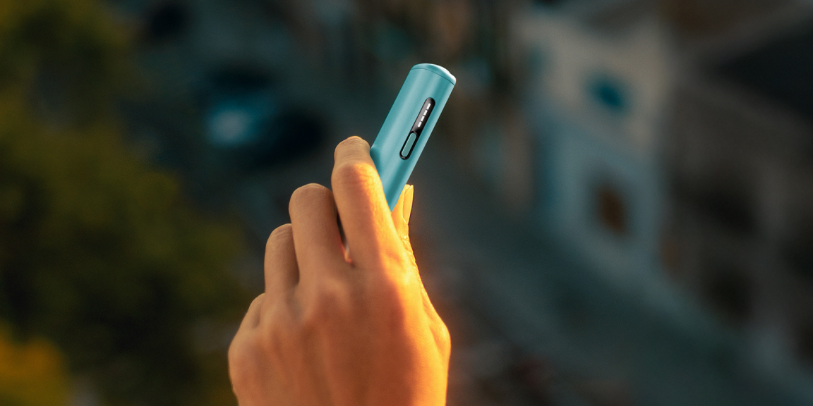 Mani che aprono la scatola un dispositivo IQOS.