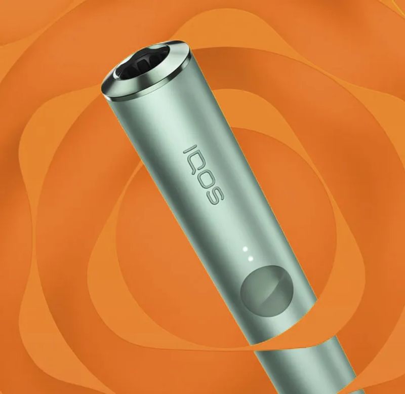 A jade green IQOS ILUMA PRIME device.