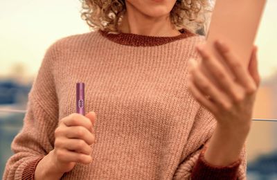 Woman performing self-diagnosis on her IQOS ILUMA i PRIME