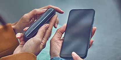 Man checking his phone with the IQOS device on the table