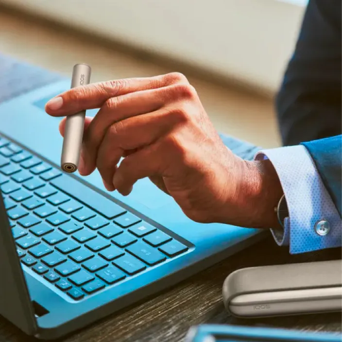 A Stellar Blue IQOS on a notebook.