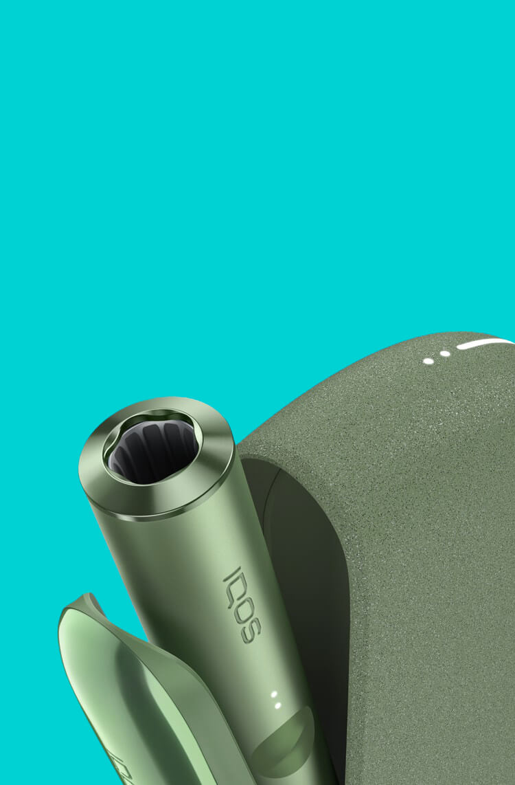 A Moss Green IQOS ILUMA device inside a charger with its door open.